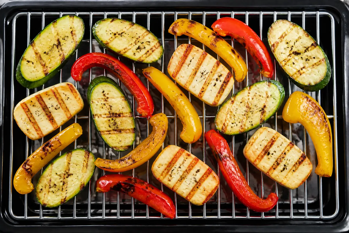 Grilled courgette, peppers and halloumi with grill marks on a chrome grate